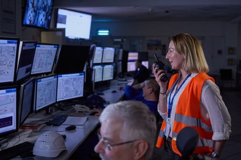 Responsable en gilet orange dans une salle de contrôle